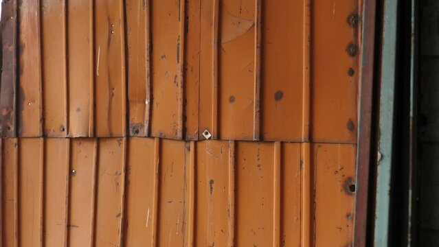 A large pan is an old rusty metal wall in a ruined building. Abandoned production. Destruction.