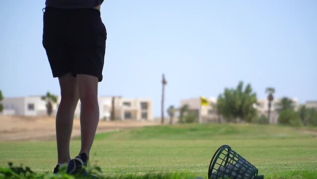 Driving Range Golf. Man practicing with golf club. Slow motion