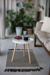 Table with croissant, cup and soft couch in light balcony room