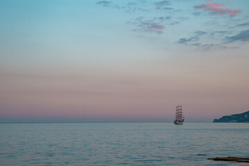 Sailboat in the sea in the evening sunlight over beautiful big mountains background, luxury summer adventure, active vacation in Mediterranean sea. High quality photo