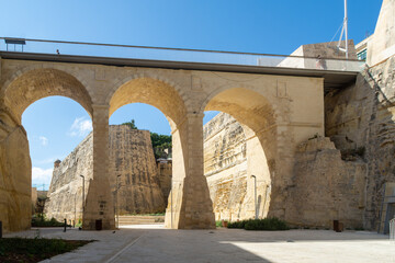 Obraz premium The Valletta Ditch with the bridge leading to the city gate, in the background is Saint John's Bastion - Valletta, Malta.