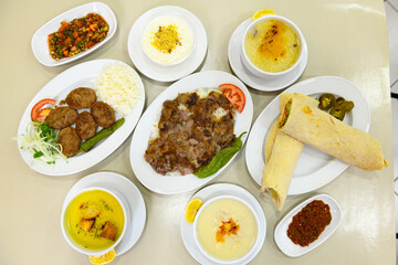 Traditional Turkish cuisine. Pizza, pita, pidesi, sucuk, hummus, kebab. Many dishes on the table. Serving dishes in restaurant. Background image. Top view, flat lay