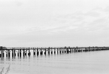 Fishing pier, small waves on a gray early morning. 