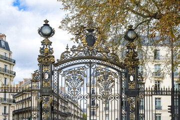 Paris, in the beautiful parc Monceau, the golden wrought iron grid, with typical buildings in...