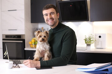 Attractive man working from home with his lap dog