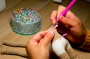manos tejiendo crochet.
mujer haciendo amigurumi de lana - obrazy, fototapety, plakaty