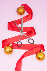Professional scissors for thinning hair on a pink background with a New Year's decor. New Year,...