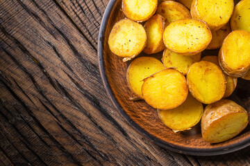 Fried potato wedges on a dark wooden background