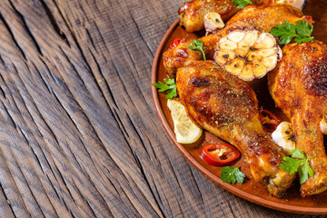 fried chicken leg on a plate with seasonings on a dark wooden background