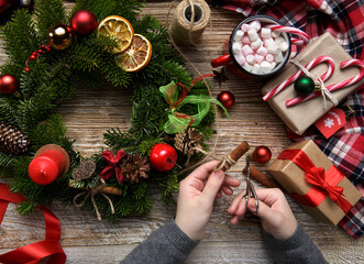 Christmas home decoration, female hands holding a wreath, hand made. Flat lay.High quality photo