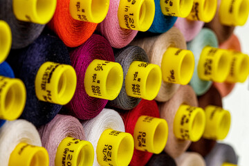 set of multi-colored spools of thread for sewing