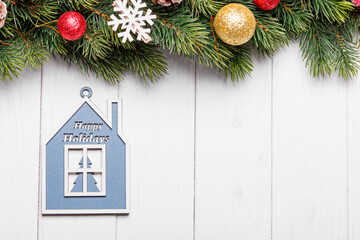 beautiful branches of a Christmas tree with cones and toys on a white wooden background with the inscription Merry Christmas