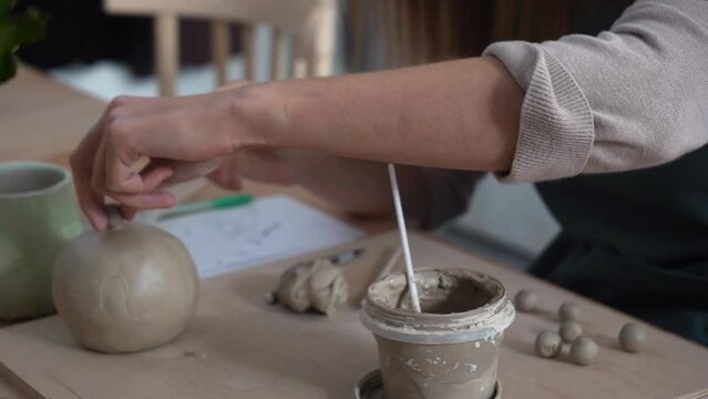 Woman's hands sculpt from a clay. Pottery workshop class. 