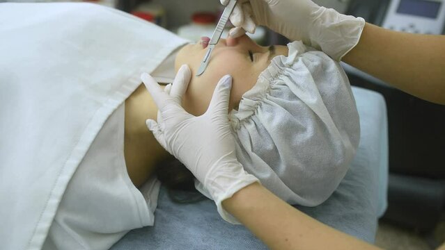 skin treatment with the dermaplaning technique performed with a scalpel by a beautician in a center of aesthetics and beauty of the body and skin