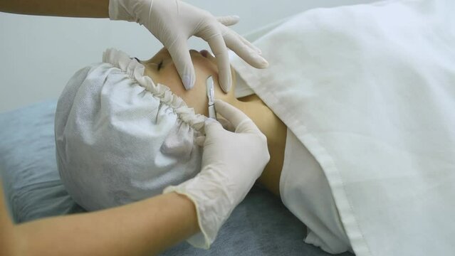 skin treatment with the dermaplaning technique performed with a scalpel by a beautician in a center of aesthetics and beauty of the body and skin