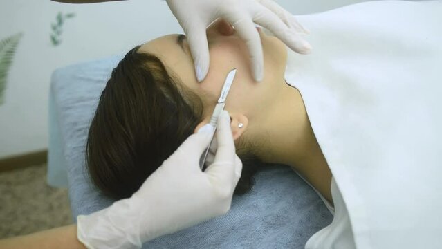 skin treatment with the dermaplaning technique performed with a scalpel by a beautician in a center of aesthetics and beauty of the body and skin
