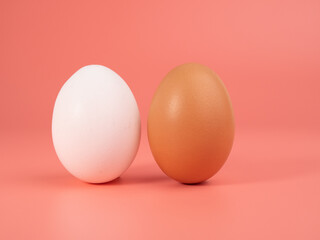 Chicken eggs on a pink background. White and brown egg on a pink background.