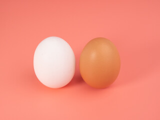 Fototapeta premium Chicken eggs on a pink background. White and brown egg on a pink background.