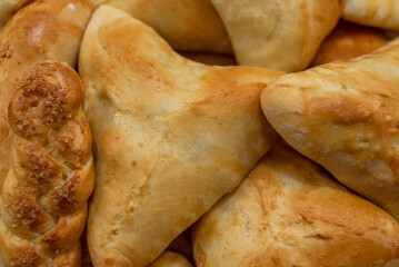 Freshly baked pies and buns with a golden crust, triangular shape and pigtail