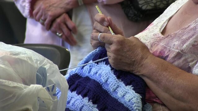 Elderly hands knitting wool.