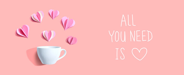 All you need is love message with a coffee cup and paper hearts - flat lay