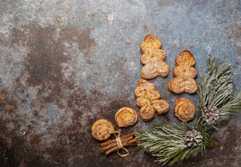christmas puff pastry cookies in the form of Christmas trees on a dark table. view from above