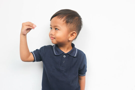 A toddler boy raised hand with gesture and looking at it