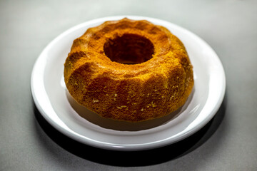 Unmoulded carrot cake on a white plate.