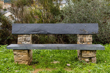 Empty stone bench on the road to rest. Tranquility, solitude, nobody, rural.
