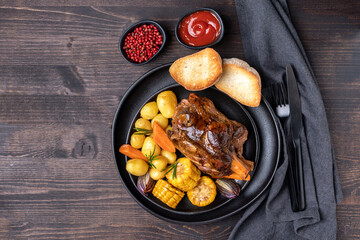 Pork shank knuckle with baked potatoes and corn	