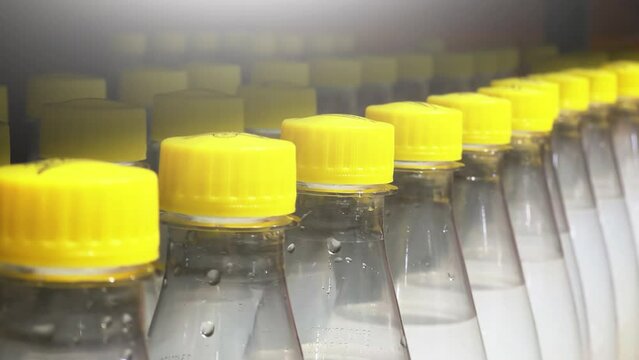 Plastic soda bottles lined up on supermarket shelves. Closeup 