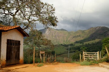 
Rural scene of the field with a dirt road and trees in the city of Serro, Cabeça de Boi village in Minas Gerais. In the background, nature with green vegetation and mountains.