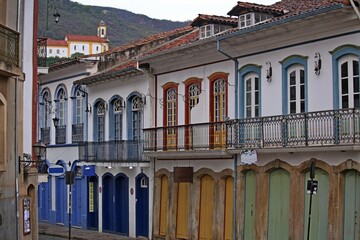 City of Ouro Preto, Minas Gerais UNESCO cultural heritage. Street with facade old two-story houses in Portuguese colonial style, arched windows and doors, colored walls.