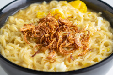 instant noodle with fried shallots on black bowl with chopstick
