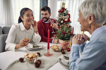 Cheerful family at the dining table for Christmas dinner at home