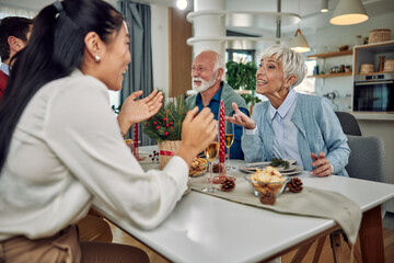 Cheerful family at the dining table for Christmas dinner at home