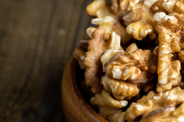 Peeled walnuts in a wooden bowl on the table