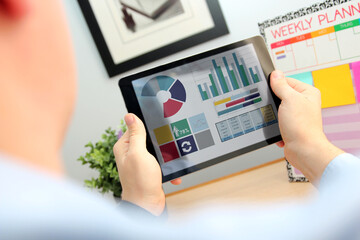 Business man working and analyzing financial figures on   a tablet