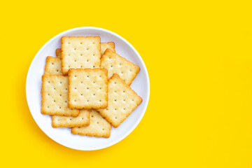 Dry cracker cookies on yellow background.