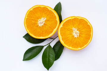 Orange fruit with green leaves on white background.