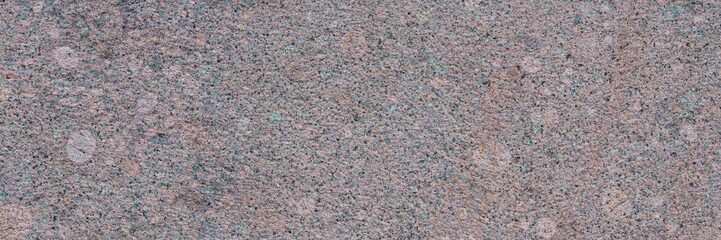 Granite texture. Natural pink granite with a grainy pattern. Stone background. Solid rough surface of rock. Durable construction and decoration material. Close-up.