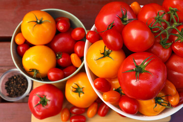 Bowls with fresh tomatoes and spices on wooden table, flat lay