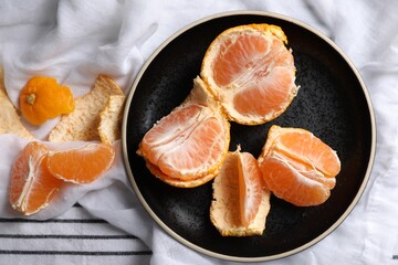 Fresh ripe tangerines on striped cloth, flat lay