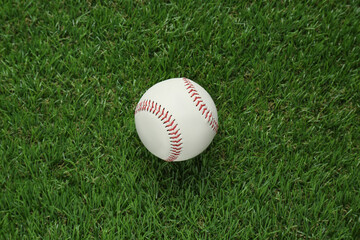 Baseball ball on green grass, top view. Sports game