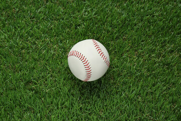 Baseball ball on green grass, top view. Sports game
