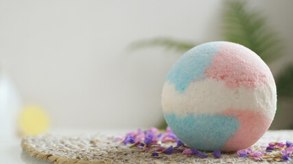 Beautiful bath bomb on wicker mat indoors, space for text