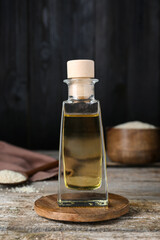 Bottle of organic sesame oil on wooden table, closeup