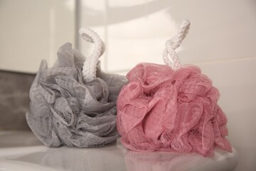 Colorful shower puffs on sink in bathroom, closeup