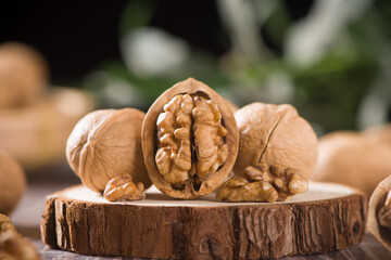 Walnut kernels and whole walnuts on wooden table.