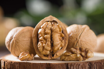 Walnut kernels and whole walnuts on wooden table.